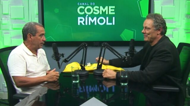 Ex-jogador Zinho concede entrevista ao jornalista Cosme Rímoli em estúdio, ambos sentados frente a frente com microfones, fundo verde com logotipo do canal, camisa da seleção sobre a mesa