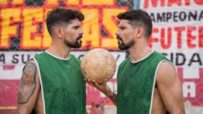 Alan (Tiago Homci) e Alberto (Diego Homci) se encaram segurando bola de futebol em cena do filme Teste para Cardíaco