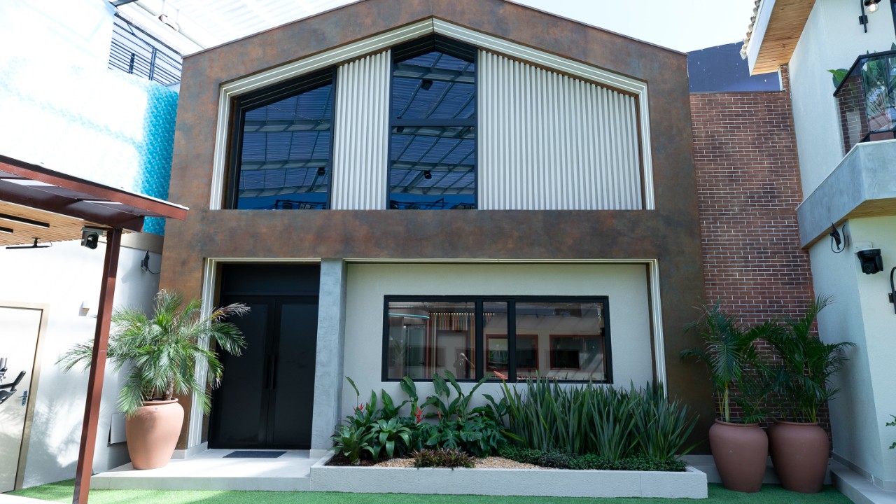 Fachada da Casa de Convivência do Casa do Patrão com jardim, janelas amplas e porta de entrada em destaque