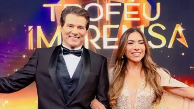 Celso Portiolli de smoking e Patricia Abravanel com vestido brilhante apresentam o Troféu Imprensa no palco do SBT