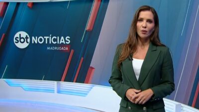 Fabíola Corrêa apresenta o SBT Notícias Madrugada em estúdio com telão do programa ao fundo