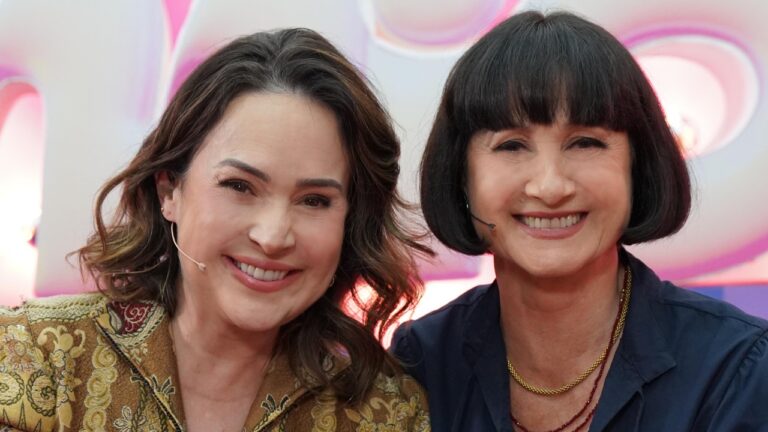 Gabriela Duarte e Zezé Polessa sorrindo lado a lado no palco do Caldeirão com Mion em estúdio iluminado