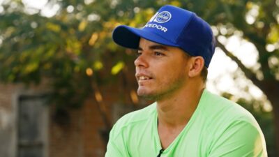 Atleta Galeguinho usa boné azul e camiseta verde durante entrevista ao ar livre exibida no Esporte Espetacular
