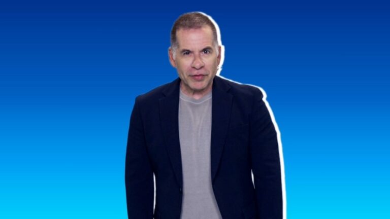O ator Leandro Hassum encara a câmera com expressão neutra usando blazer azul marinho sobre camiseta cinza em fundo degradê azul e contorno branco