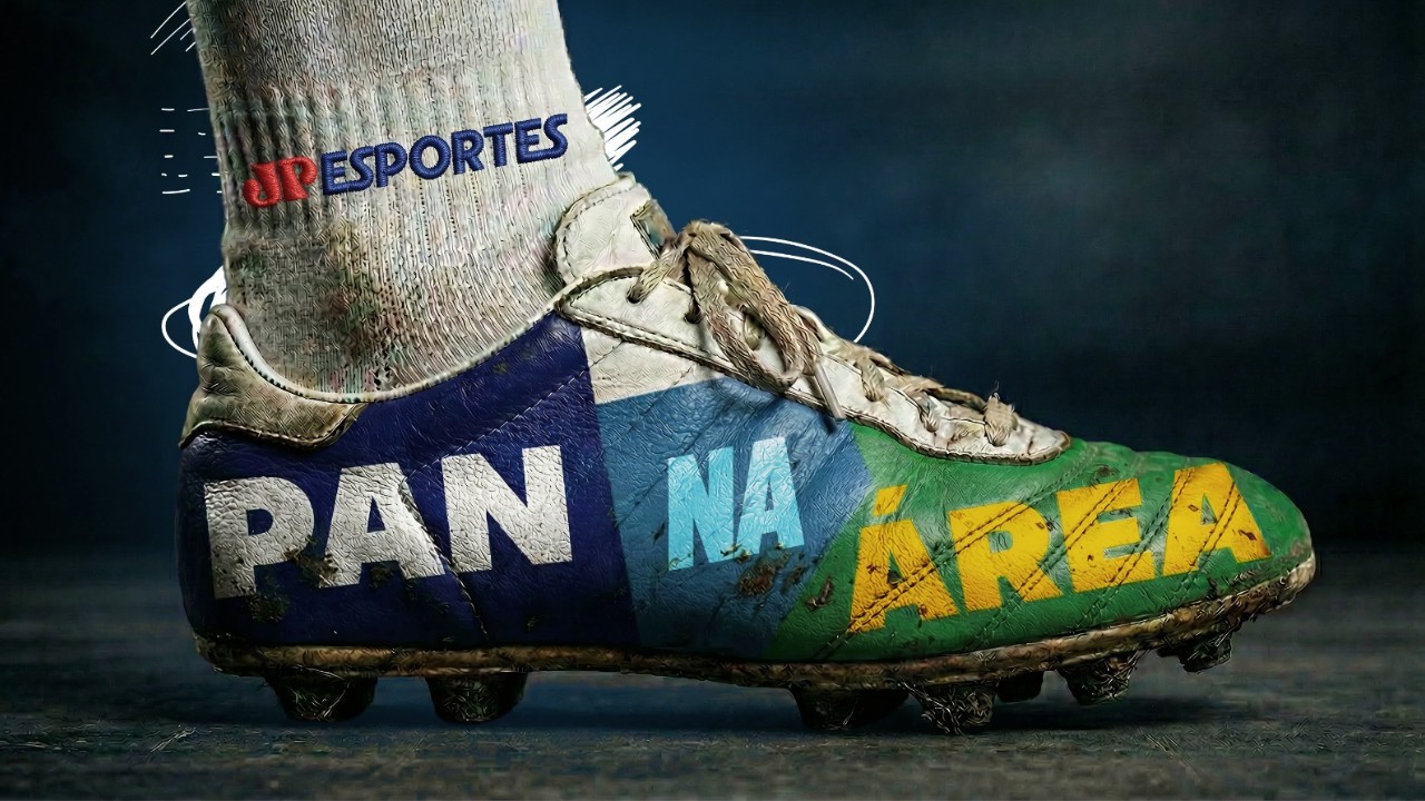 Chuteira de futebol suja de lama com o logotipo do programa Pan na Área estampado em azul, branco, verde e amarelo, e a marca JP Esportes na meia branca, em close lateral