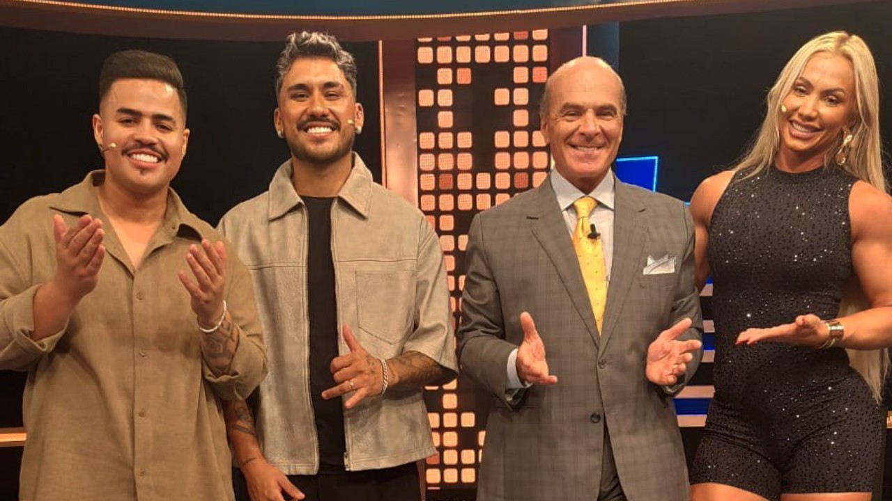 Rafa, Junior, Marcelo de Carvalho e Vivi Winkler posam juntos no palco de programa de TV com iluminação ao fundo