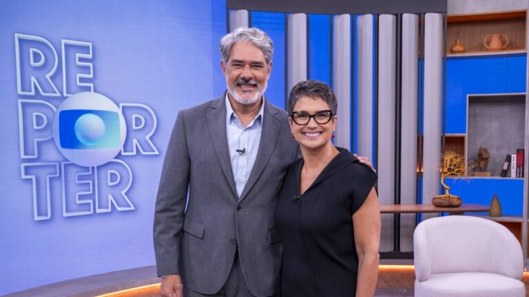 William Bonner e Sandra Annenberg posam juntos no estúdio do Globo Repórter com logotipo do programa e cenário moderno ao fundo