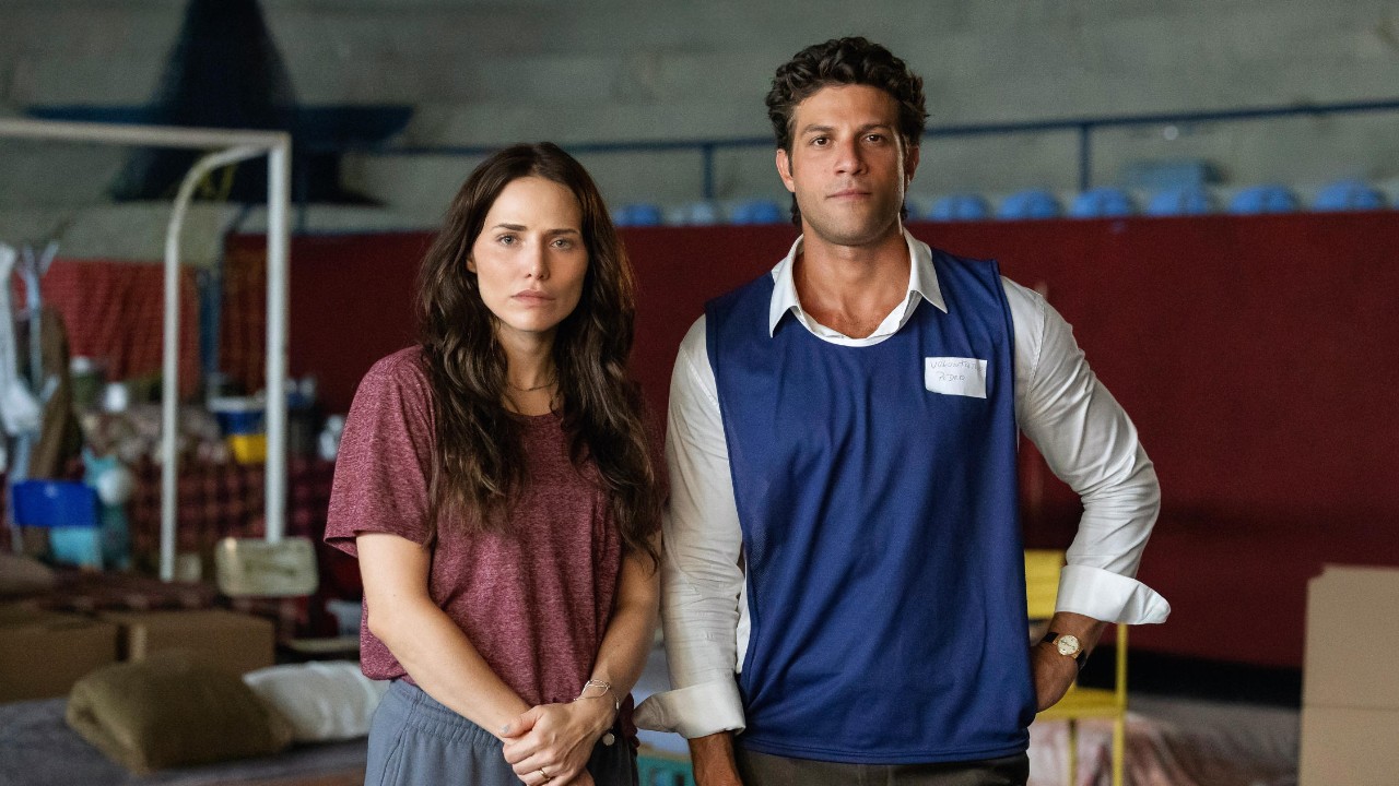 Adriana (Leticia Colin) e Pedro (Chay Suede) observam abrigo improvisado em cena da novela Quem Ama Cuida