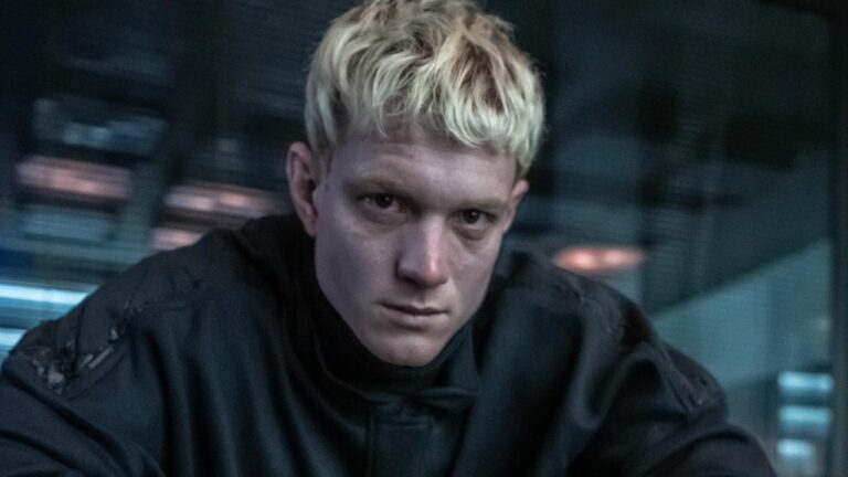 Pedro Novaes interpreta Alexandre no filme inspirado na novela A Viagem. Na imagem, o personagem aparece com cabelo platinado e expressão séria em uma cena de clima sombrio