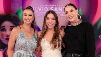 Catia Fonseca, Patricia Abravanel e Carolina Ferraz posam sorrindo no palco do Programa Silvio Santos no SBT