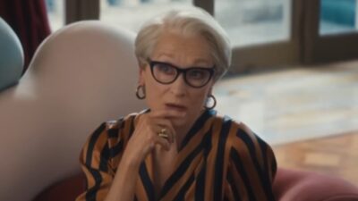 Miranda Priestly interpretada por Meryl Streep sentada em poltrona com óculos pretos em cena de O Diabo Veste Prada 2