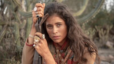 Rosa (Isadora Cruz) segura espingarda em cenário árido do sertão em cena da novela Guerreiros do Sol