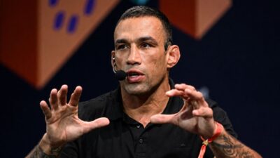Fabrício Werdum gesticula durante palestra com microfone de cabeça em evento sobre esporte e artes marciais