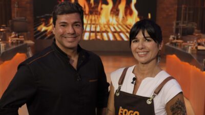 Felipe Bronze e chef Dani França no estúdio de No Fogo com Bronze diante de churrasqueira acesa ao fundo