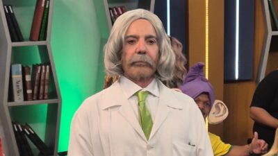 João Kleber caracterizado como professor João Raimundo durante quadro Escolinha da Copa em estúdio de televisão