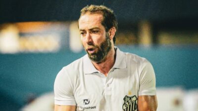 Paulo Massaro de camisa polo branca do Santos gesticula à beira do campo durante partida de futebol