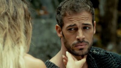 William Levy com expressão tensa enquanto mulher toca seu queixo em cena do filme The Veil