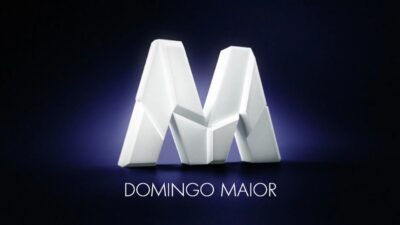 Logotipo do Domingo Maior com letra M branca em formato geométrico sobre fundo escuro com nome da sessão abaixo