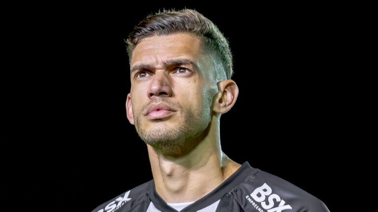 Lucas Dias com uniforme de time de futebol olha para o alto durante apresentação em fundo preto