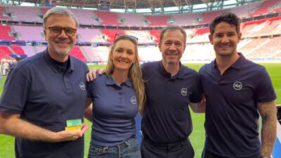 Mauro Beting, Nadine Basttos, Tiago Leifert e Alexandre Pato posam lado a lado à beira do gramado de estádio de futebol vazio
