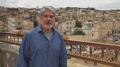 William Bonner de camisa azul posa diante do curtume de Fez com vista da cidade ao fundo no Marrocos