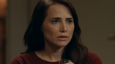 Adriana (Leticia Colin) segura uma xícara e olha apreensiva para o lado em cena da novela Quem Ama Cuida