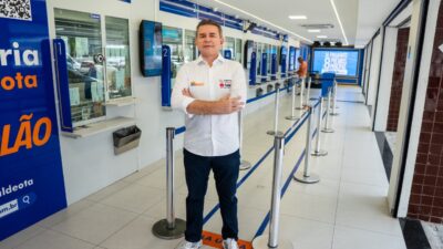 Alessandro Montenegro de camisa branca e braços cruzados em unidade da Loteria Aldeota