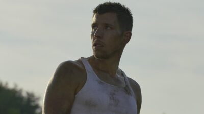 Martin Duran Jr. (Beau Knapp) de regata branca suja olha para o lado em cena de Crypto - Máfia Digital