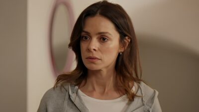 Karsu (Ozge Ozpirincci) com expressão séria veste moletom cinza e camiseta branca em cena da novela Coração de Mãe