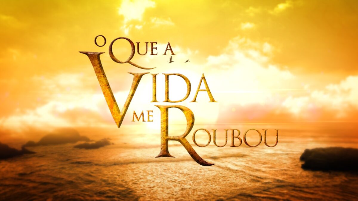 Logotipo da novela O Que a Vida Me Roubou em letras douradas sobre céu alaranjado com nuvens iluminadas e mar ao pôr do sol ao fundo