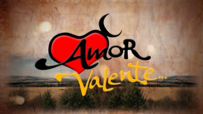 Logotipo da novela Amor Valente com coração vermelho estilizado sobre paisagem rural ao fundo