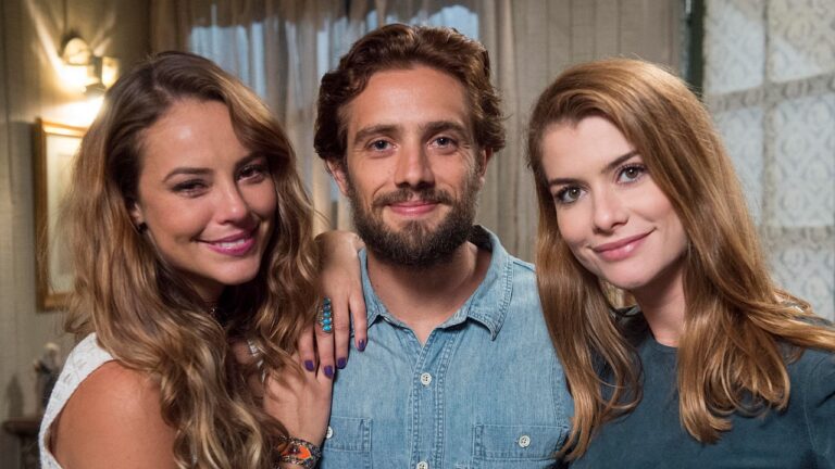 Melissa (Paolla Oliveira), Felipe (Rafael Cardoso) e Lívia (Alinne Moraes) sorrindo juntos em cenário interno de Além do Tempo