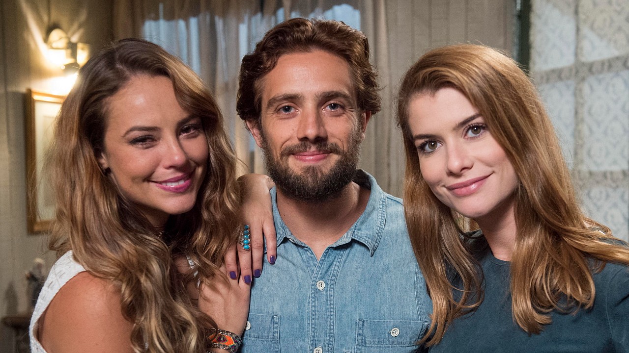 Melissa (Paolla Oliveira), Felipe (Rafael Cardoso) e Lívia (Alinne Moraes) sorrindo juntos em cenário interno de Além do Tempo
