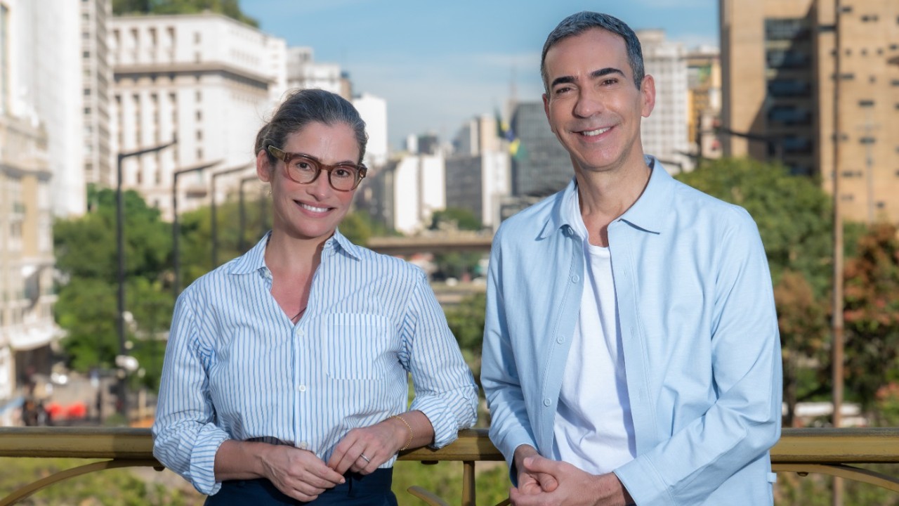 Renata Vasconcellos de óculos e César Tralli sorriem lado a lado no Viaduto Santa Ifigênia, em São Paulo