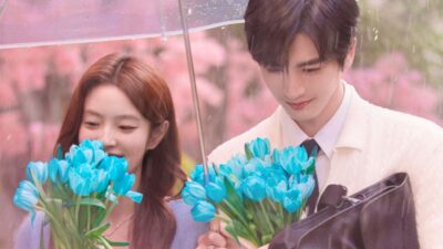 Shen Xifan (Xu Ruohan) e He Suye (Zhang Linghe) seguram tulipas azuis sob guarda-chuva em O Melhor de Tudo