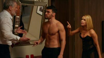 Ademir (Dan Stulbach) gesticula diante de André (Henrique Barreira) sem camisa, enquanto Dora (Mariana Ximenes) aponta o dedo indicador