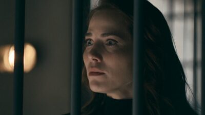 Adriana (Leticia Colin) olha apreensiva entre grades em ambiente escuro na novela Quem Ama Cuida