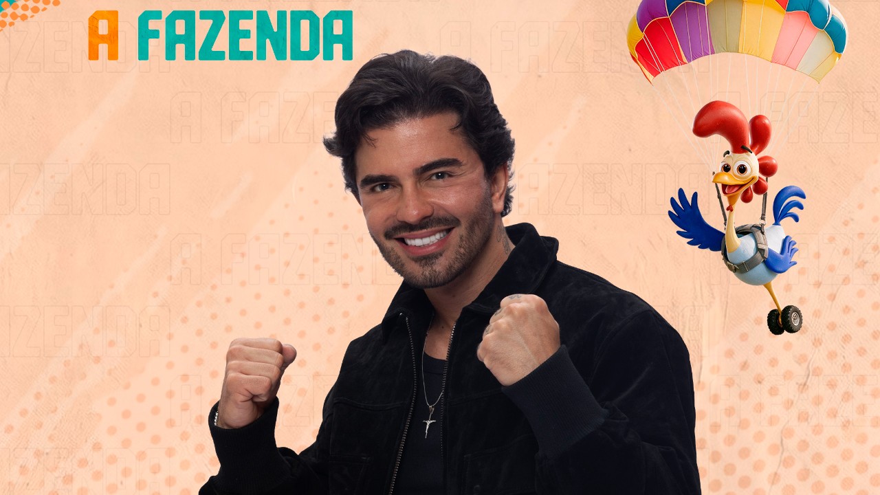 Alfredo Amaral sorri de jaqueta preta com os punhos erguidos diante do logo de A Fazenda