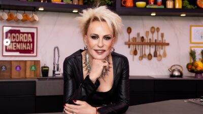 Ana Maria Braga de roupa preta posa apoiada em bancada na cozinha do programa Mais Você