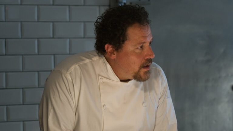 Carl Casper (Jon Favreau) de uniforme branco de chef em cena do filme Chef