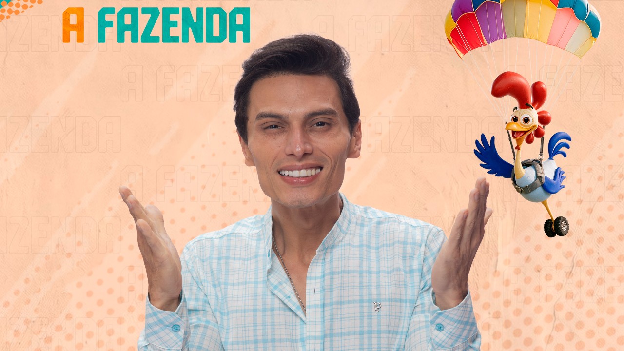 Gabriel Torres sorri de camisa xadrez clara com as mãos erguidas diante do logo de A Fazenda