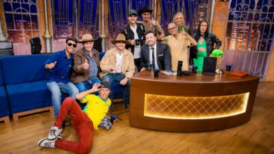Gustavo Tubarão e turma de Cana Verde posam com Danilo Gentili no cenário do The Noite, reunidos ao redor da bancada