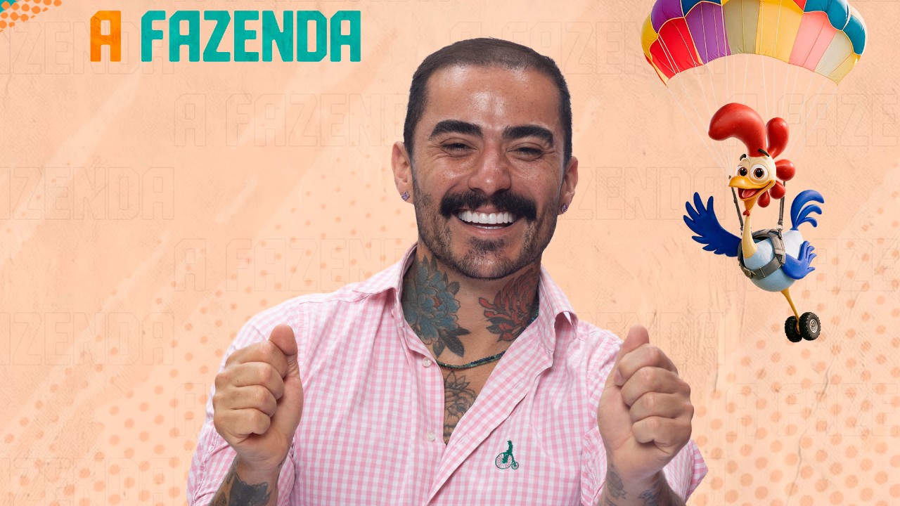 Mayk Leão sorri de camisa xadrez rosa, com bigode e pescoço tatuado, diante do logo de A Fazenda