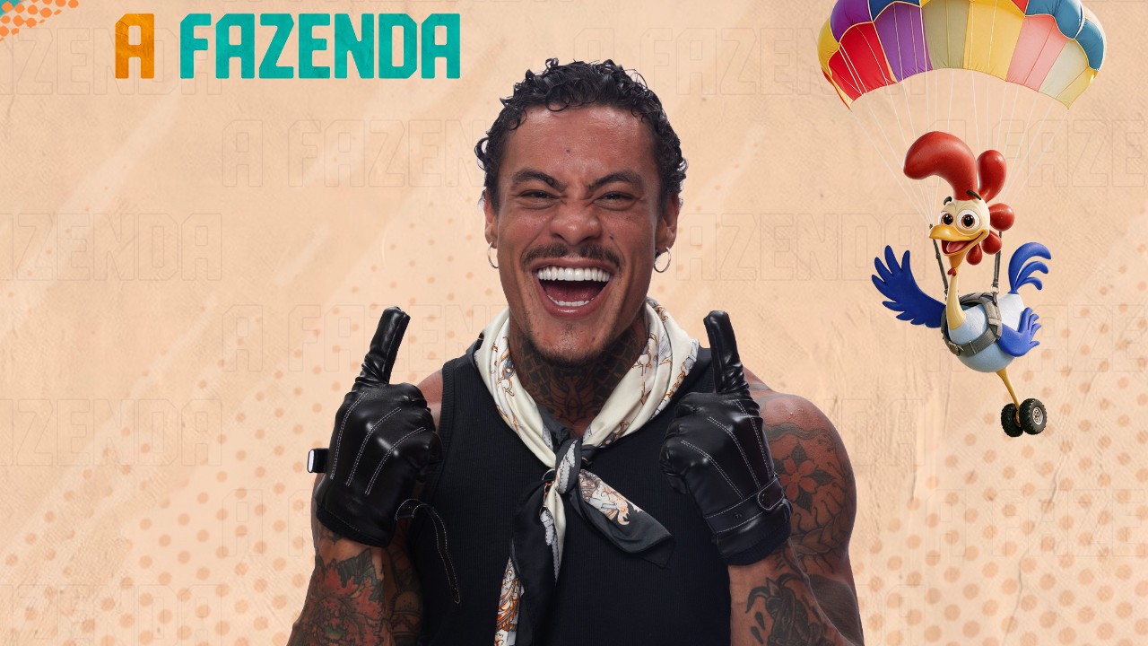 Murilo Diaz sorri de regata preta, lenço no pescoço e luvas, com indicadores erguidos diante do logo de A Fazenda