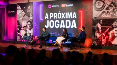 Executivos conversam no palco diante de painel da TNT Sports e YouTube com a frase A Próxima Jogada