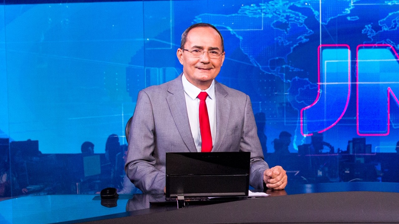 Ayres Rocha aparece de terno cinza e gravata vermelha na bancada do Jornal Nacional