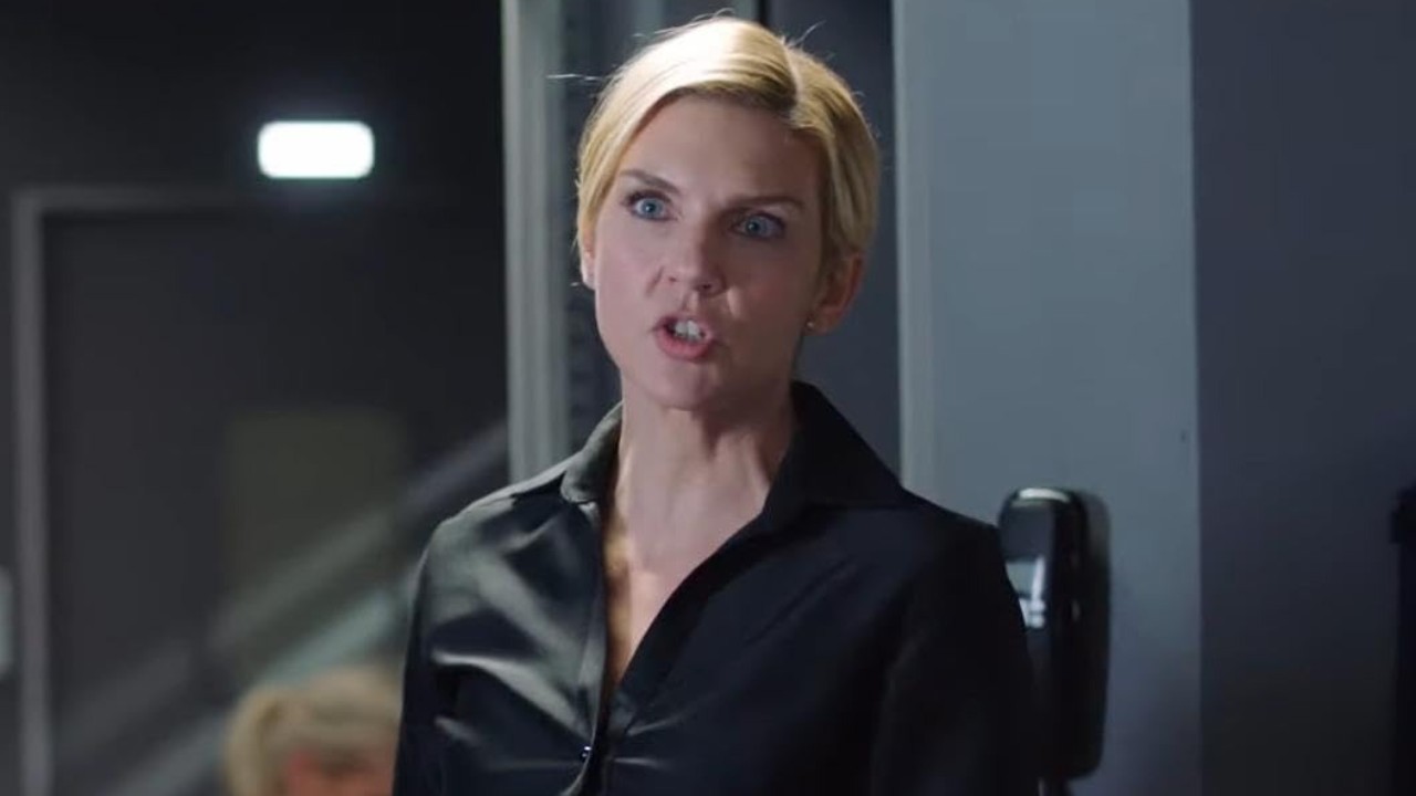 Brynn Stewart (Rhea Seehorn) aparece com expressão séria, cabelos loiros presos e roupa preta em uma cena do filme O Plano Perfeito 2