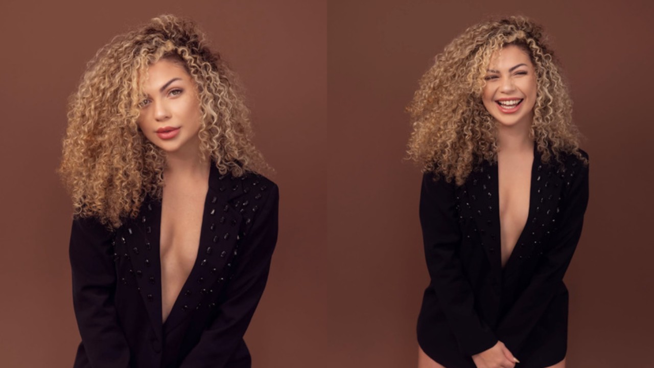 Daniella Motta aparece em duas poses, com cabelos loiros cacheados e blazer preto, diante de um fundo marrom