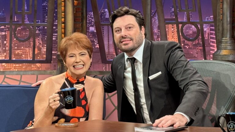 Narjara Turetta e Danilo Gentili aparecem sorridentes no cenário do The Noite, no SBT